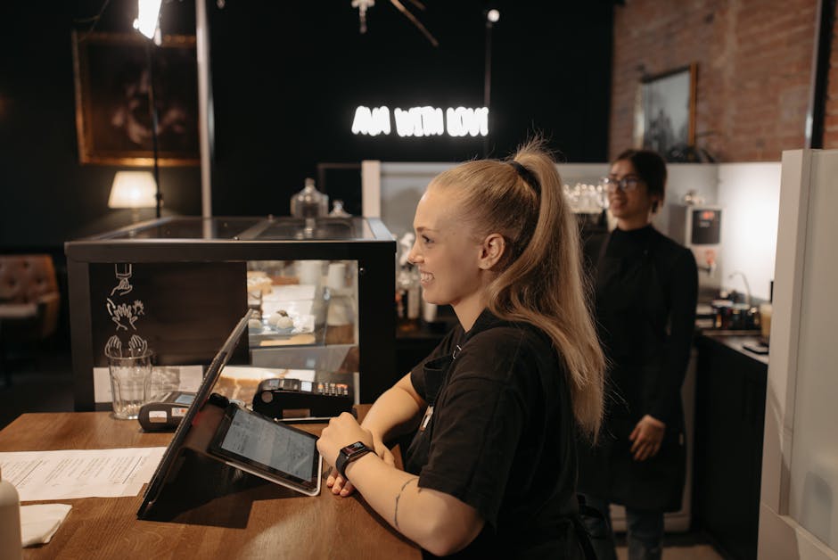 Een barista bedient een tablet in een café