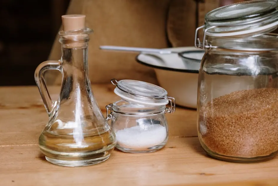 Assorted kitchen ingredients in glass jars on a wooden countertop.