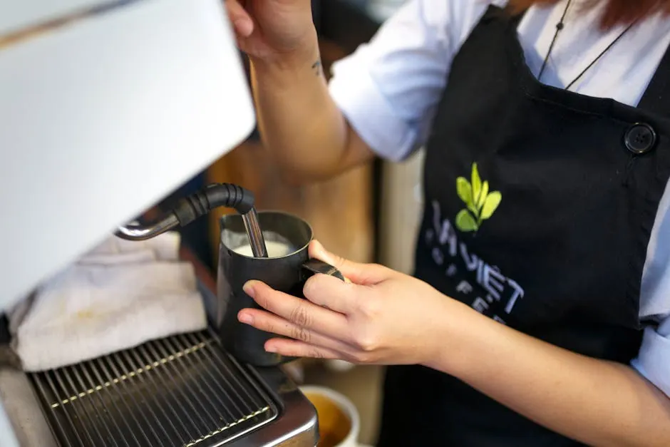 Een barista stoomt melk voor cappuccino